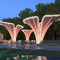 Illuminated Petal Shaped Pergola In Night Garden With Trees Water And Seats