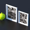 Two White Picture Frames With Black And White Photos And Yellow Spherical Object Dark Background