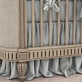 Classic Beige Upholstered Baby Crib With Bow Ties Soft Blanket And Ruffled Skirt