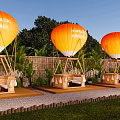 Nomadic Voyage Campsite With Orange Hot Air Balloons Bamboo Structures And Lush Greenery