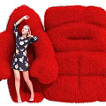 Giant Red Furry Art Installation Sofa Chair With Woman Interacting Nearby