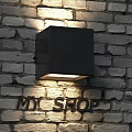 Black Square Wall Lamp Mounted On Brick Wall Illuminating Wall Surface And MY SHOP Letters