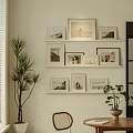 Stylish Photo Wall Decor with Framed Pictures on White Wall and Potted Plants