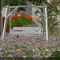 White Hanging Chair in Outdoor Garden with Colorful Flowers Tree Building Green Plants and Butterflies