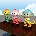 Three Colorful Monkey Sculptures On Wooden Table With Blue Sky White Clouds