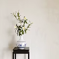 Blue and White Vase with White Flowers and Green Leaves on Dark Table Light Wall