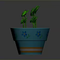 Green Potted Plant With Fresh Leaves In Blue Flower Patterned Pot With Orange Stripes