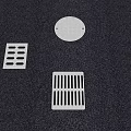 Various Stainless Steel Drain Grates And Covers On Dark Textured Surface