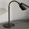 Black Desk Lamp With Golden Curved Arm Modern Design On Gray Curved Tabletop