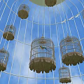 White Birdcage Art Installation Placed On Green Grass Field With Small Trees