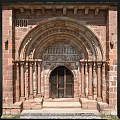 Romanesque Entrance Gate With Red Brick Structure Carved Archway Stone Columns And Wooden Doors