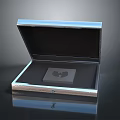 Opened Shiny Metallic Box Containing Square Item on Dark Background