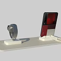Red Black Smartphone and Silver Smartwatch Digital Products on Display Stand with Charging Cable