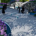 Modern White Pergola in Garden with People Enjoying Lush Greenery and Colorful Flowers