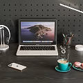 Modern Laptop On Dark Wooden Desk With Headphones Smartphone Coffee Cup Macarons And Desk Lamp