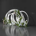 Artistic Floral Installation with Intertwined White Circular Frames White Pink Flowers and Green Foliage