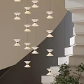 Modern Multiple Pendant Lights Hanging In Staircase With Geometric Wall And Green Plant