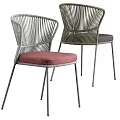 Round Outdoor Table With Metal Legs And Woven Rattan Chairs Red Black Cushions