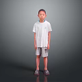 Young boy standing wearing white T-shirt gray shorts and gray shoes on gray gradient background