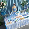 Delicious Food Buffet Table With Fresh Flowers Blue Curtains Fringed Tablecloth And Various Snacks