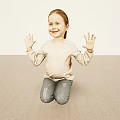 Little Girl With Reddish Brown Hair Waving Hands Kneeling On Light Floor Smiling
