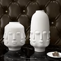 Elegant White Ceramic Vases with Face Motifs on Brown Leather Background and Black Marble Table