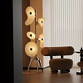 Modern Floor Lamp With Multiple Circular Shades Metal Stand And Beige Chair In Living Room
