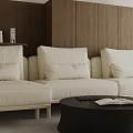 Cream Colored Three Seater Sofa With Cushions And Black Round Coffee Table Wooden Wall Background