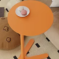 Pink Round Functional Table Next to Sofa With Cup Saucer on Top and Stuffed Toy