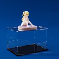 Doll Figure Sitting with Blonde Twin Tails on Purple Base in Clear Acrylic Display Case