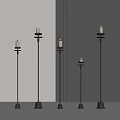 Five slim black candle shaped floor lamps in modern neutral room with gray walls