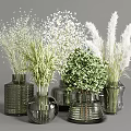 Various Textured Glass Vases Arranged With White Small Flowers Green Leafy Plants And Pampas Grass