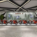 Modern Ducati Reception Area With White Reception Desk Geometric Backdrop Green Plants And Motorcycle Posters