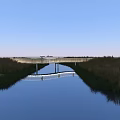 Scenic Landscape Bridge Over Calm Waterway With Reflection And Grassland Under Blue Sky