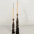 Decorative Gold And Black Candle Holders With White Candles On White Wall Background