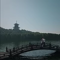 Ancient Pagoda Scenery by Lake with Arch Bridge People and Green Trees