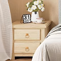 Wooden Nightstand with Two Drawers Gold Handles White Vase Flowers Calendar and Cup