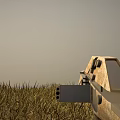 Rifle Weapon Lying On Green Grass Field With Clear Sky Above