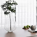 Transparent Teardrop Vase With Green Plant On Wooden Tabletop And Decorative Green Fruits Gray Spheres