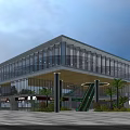 Modern Sales Office Building With Glass Curtain Walls Nighttime Lighting And Palm Trees At Entrance