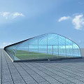 Modern Industrial Factory Building With Glass Arched Roof And Spacious Ground Under Clear Blue Sky