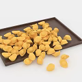 Brown Tray With Scattered Yellow Shell Shaped Items On White Background