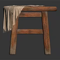 Round Wooden Stool with a Beige Cloth Draped Over the Seat and Solid Legs