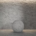 Gray Spherical Sculpture With Carved Texture Against Textured Gray Wall On Light Surface 3d model