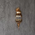 Golden Wall Lamp With Intricate Patterns Transparent Shade And Crown Design On Gray Rough Wall