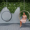 Round Indoor Hanging Chair With Green Plant Wall And Woman Sitting Comfortably