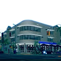 Art Deco Building Exterior With Curved Facade Large Windows Hotel Sign Palm Trees And Street Cars