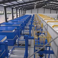 Industrial Equipment Production Line In Factory Interior With Blue And Yellow Machinery