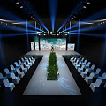 Stage With Blue Lighting Large Screen Seascape View Neatly Arranged White Chairs And Green Plants