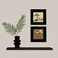 Decorative Ornament Set with Black Vase Fern Leaves and Two Framed Paintings on Wooden Table